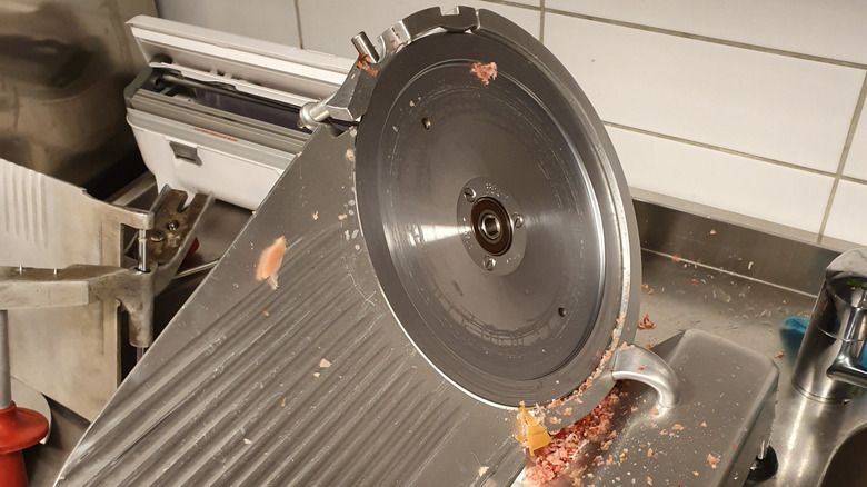 Deli slicer with meat scraps on it