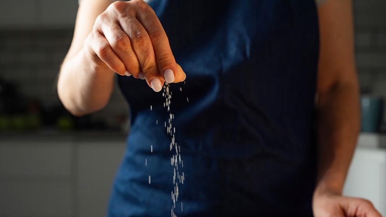 Woman's hand adding a pinch of salt