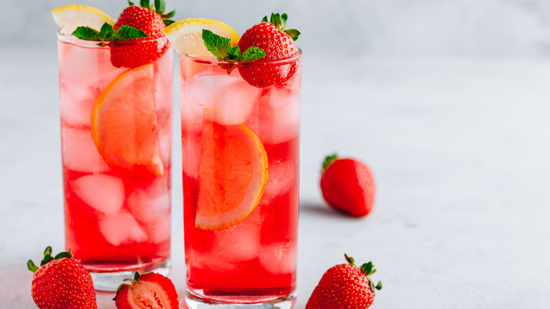 Two glasses of strawberry lemonade with fresh strawberries