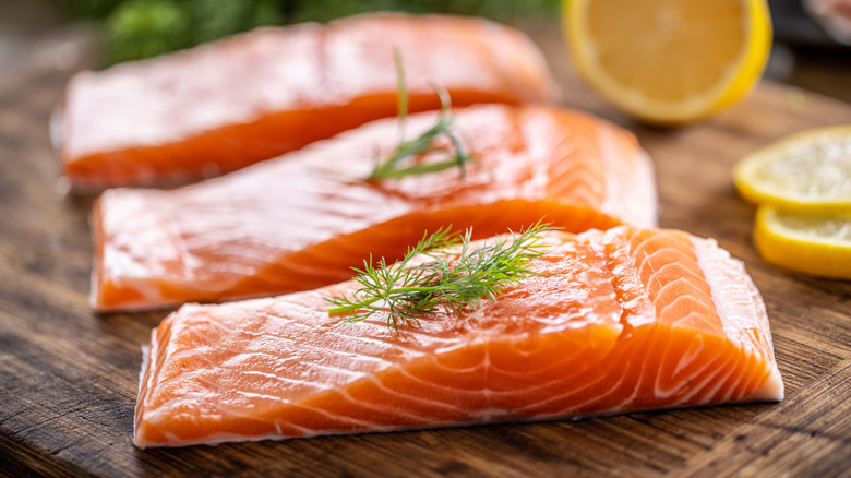 Raw salmon slices on cutting board