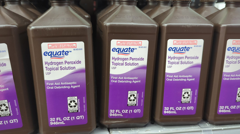 A store shelf stocked with rows of hydrogen peroxide