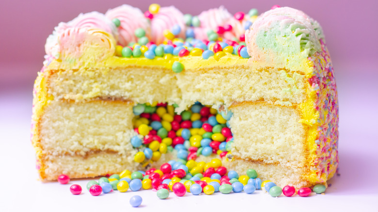 A yellow layered sponge cake filled with colorful candies