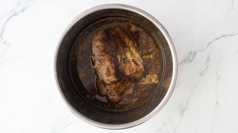 Cooked pork butt in a slow cooker pot