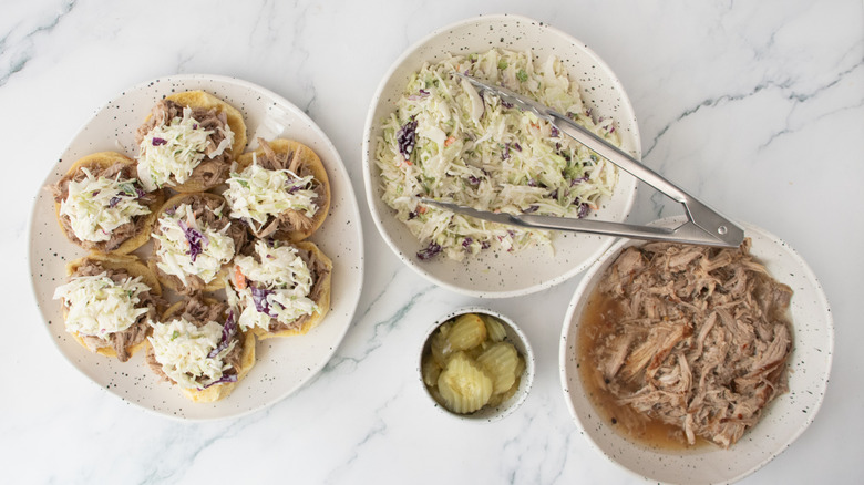 Slider roll bottoms topped with pulled pork and coleslaw