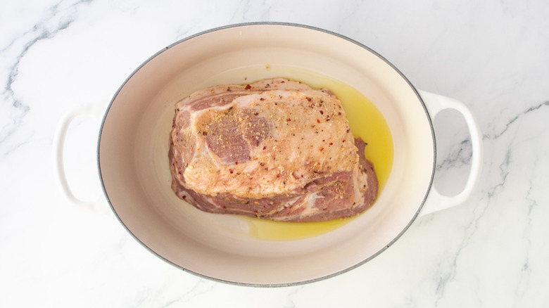 Raw pork butt in a large dutch oven