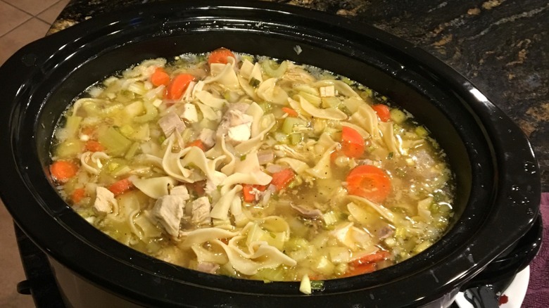 Soup in slow cooker with vegetables and noodles