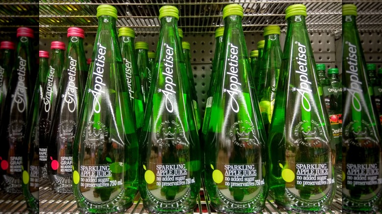 Many bottles of Appletiser on a shelf