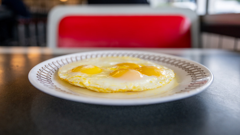 Plate of sunny side-up eggs at a Waffle House booth table