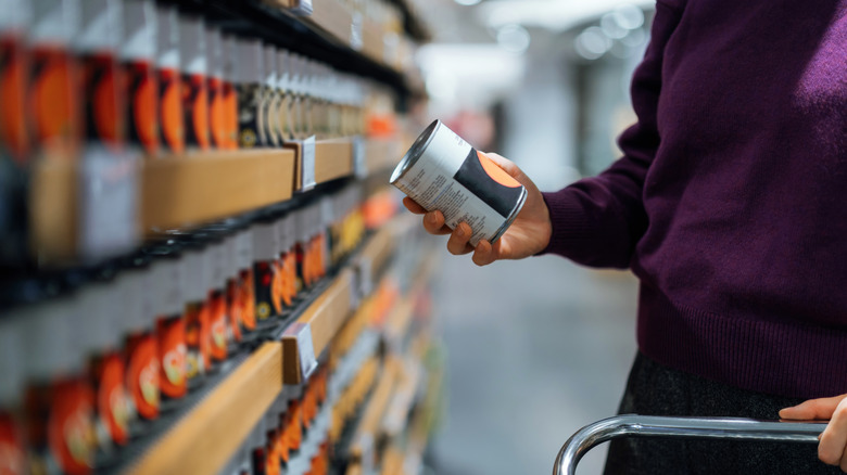 Person looking at a can at the supermarket