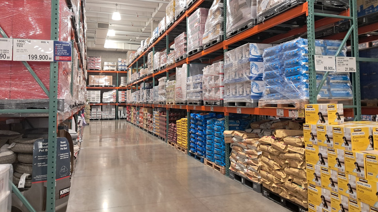Interior of a Costco warehouse in South Korea, showing tall shelves stacked with bulk products like bottled water and household goods.
