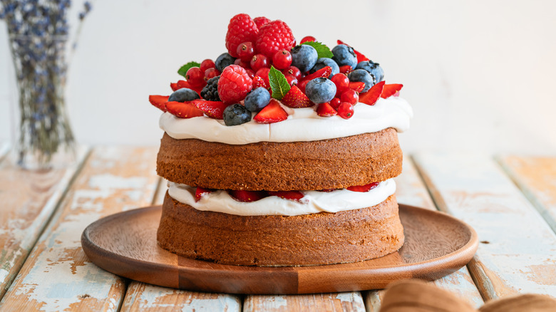 layered sponge cake with frosting and berries