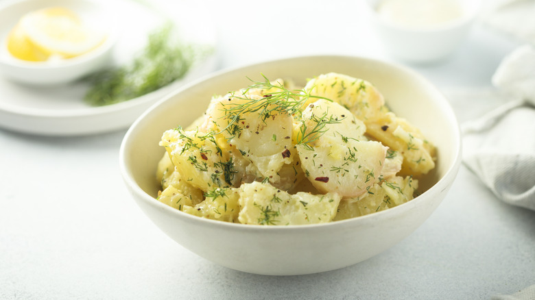 Traditional homemade potato salad with dill served in a small bowl.