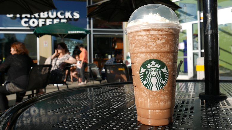 Starbucks Frappuccino on a black metal table outside a Starbucks
