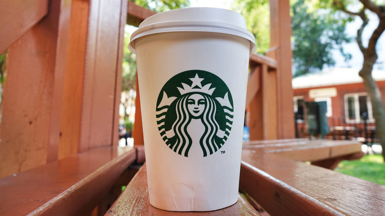 Starbucks hot to-go cup sitting on a ledge outdoors