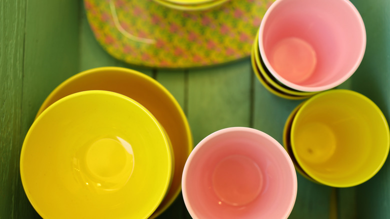 Colorful plastic cups and a stack of bowls
