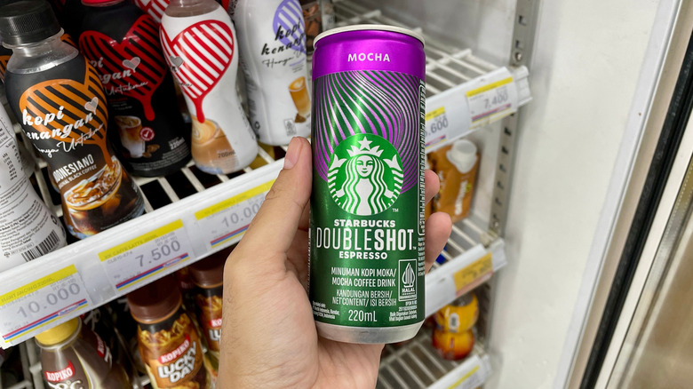 Hand pulling can of doubleshot espresso from cooler