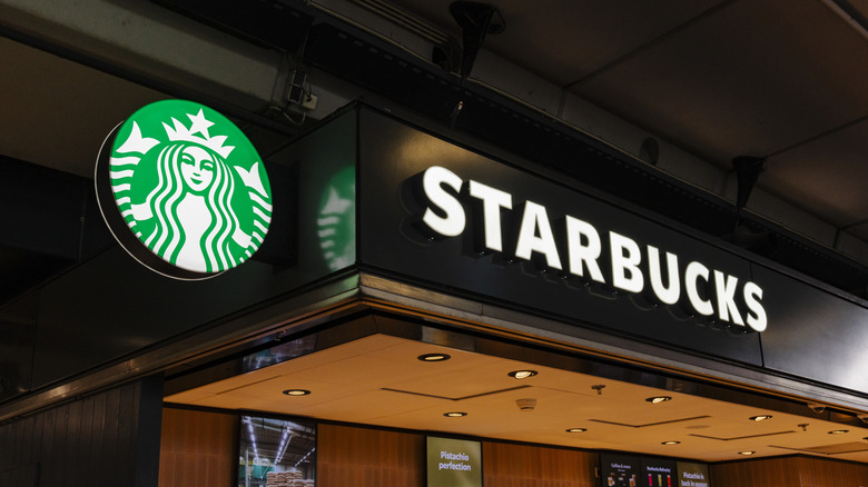 The logo and signage at an indoor Starbucks location