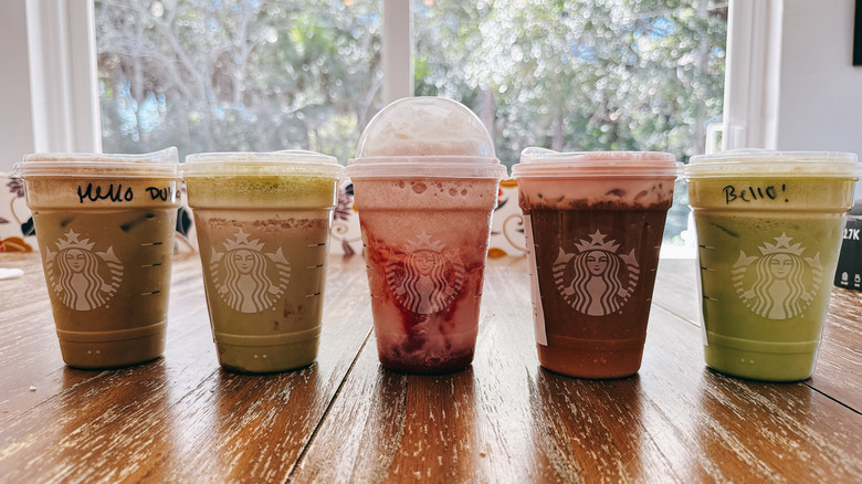 Five iced beverages from Starbucks Valentine's menu on a wooden table