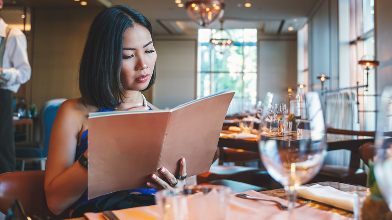 Woman looking at a menu at a restaurant