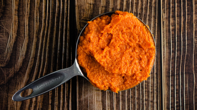 A measuring cup full of pumpkin purée