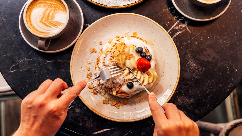 Pancakes with fruit, nuts, and whipped cream on top