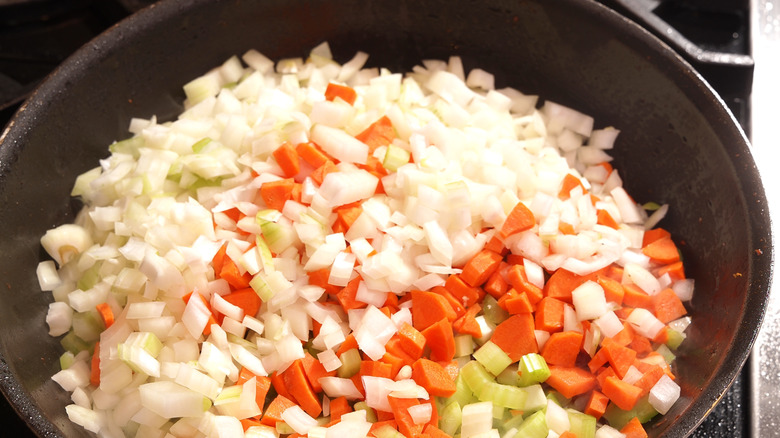 Diced onions, celery, and carrots in a skillet