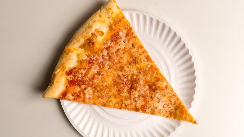 A slice of pizza on a paper plate.