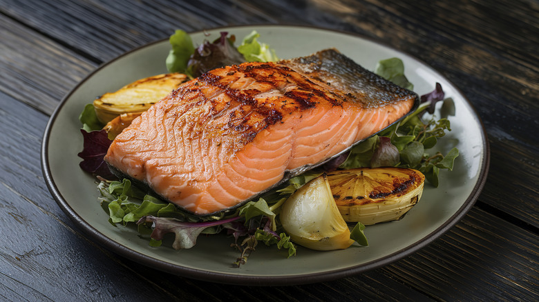 Grilled salmon on bed of salad leaves in a dish