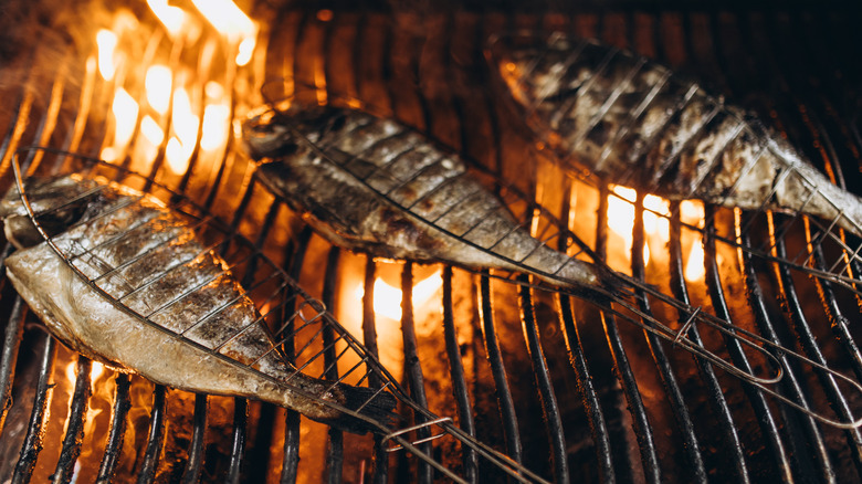 Whole fish being cooked on a hot grill