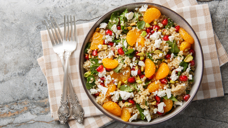 Salad with mandarin oranges, cous cous, pomegranate arils, and goat cheese