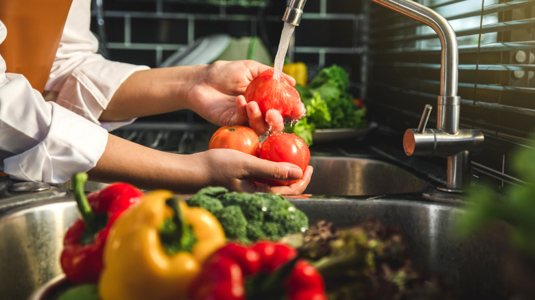 Person rinsing produce in sink