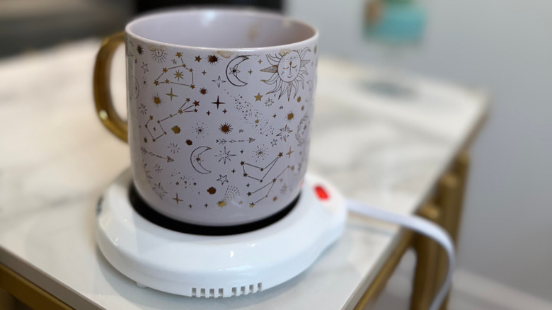 Coffee mug with constellation designs on electric warmer