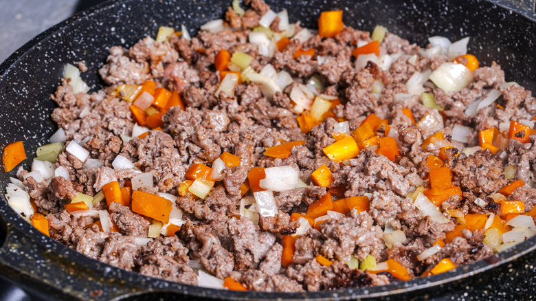 Ground beef with aromatics frying up for a bolognese sauce