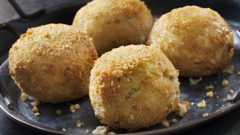 potato croquettes on a black plate