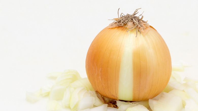 A whole raw onion with its skin slightly parted