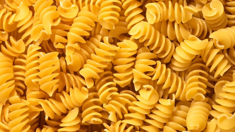 Pile of raw fusilli pasta close-up. Italian pasta, pasta cones texture, top view