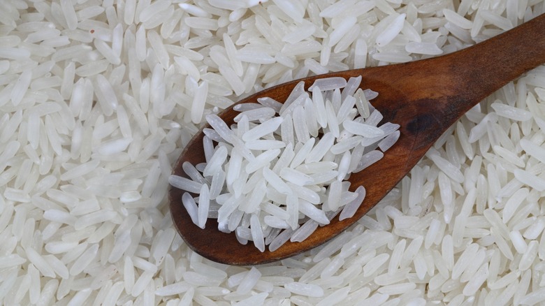 Raw white rice with wooden spoon