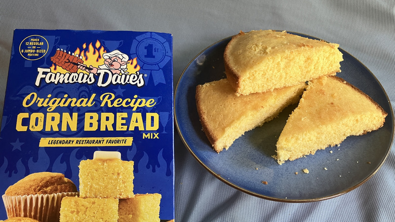 Three wedges of Famous Dave's Original Recipe Corn Bread displayed on a plate next to the blue cornbread mix box.