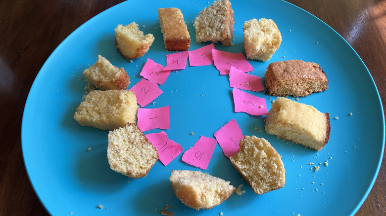 A blue platter displays 11 samples of cornbread with numbered pink slips of paper next to each one.