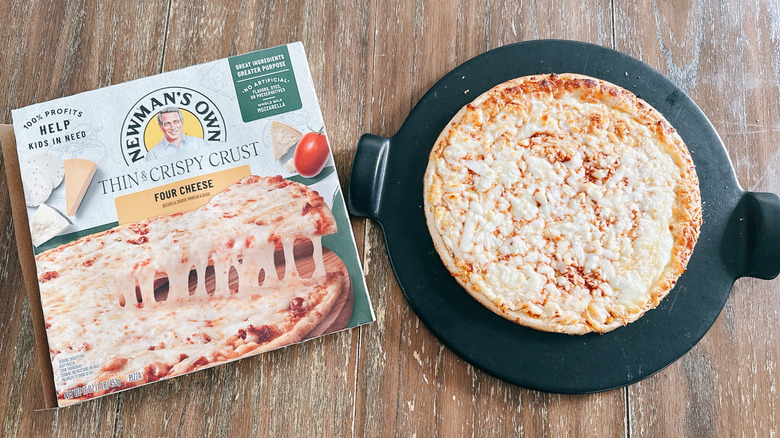 Newman's Own frozen cheese pizza next to box on wooden table