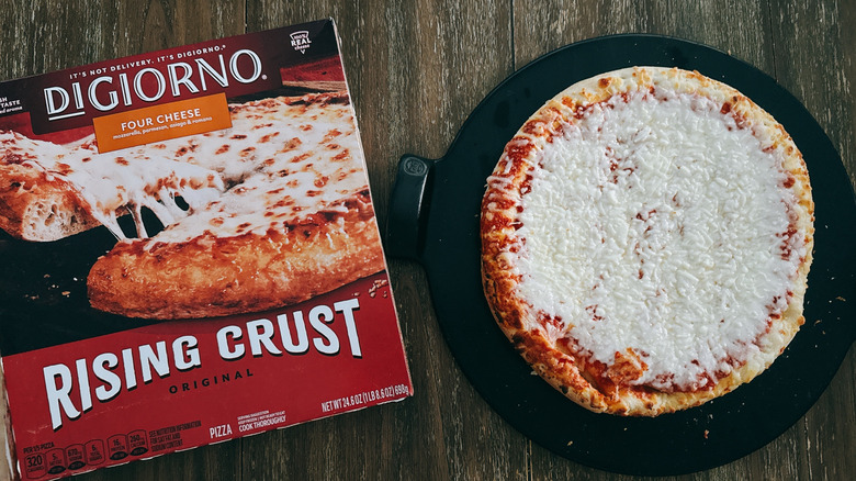 DiGiorno rising crust frozen cheese pizza next to box on wooden table
