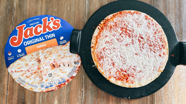 Jack's Original Thin Crust frozen cheese pizza next to box on wooden table