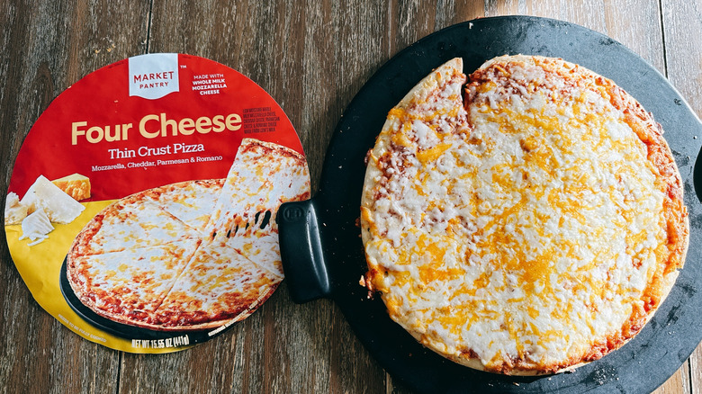 Market Pantry Thin & Crispy frozen cheese pizza next to box on wooden table