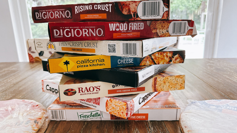 Stacked store-bought frozen cheese pizza boxes