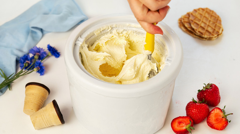 a person scooping from an ice cream maker