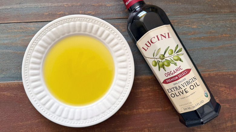 Lucini Extra Virgin Olive Oil bottle next to a dish with oil