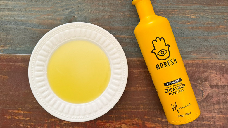 Moresh extra virgin olive oil bottle next to a dish with oil