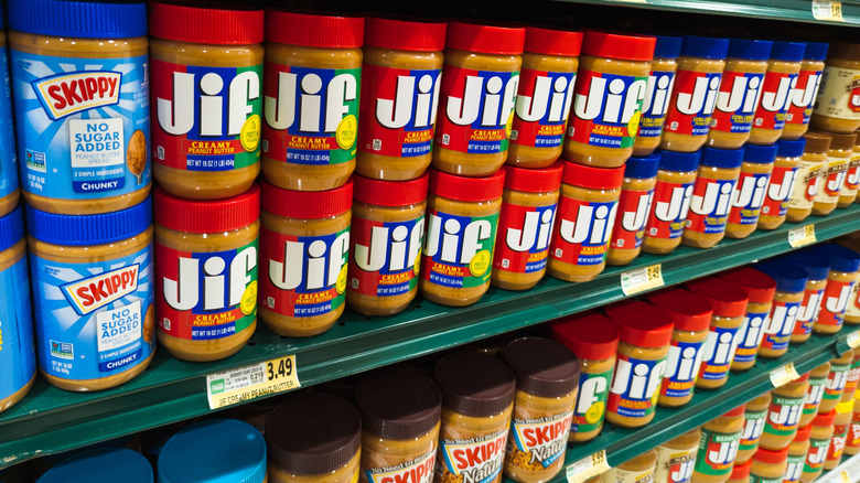 Rows of Skippy and Jiff peanut butter on grocery store shelves