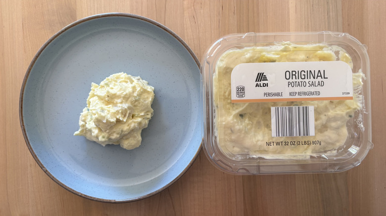 potato salad on blue plate next to plastic container of potato salad