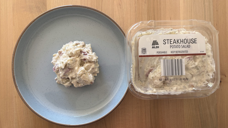 potato salad on blue plate next to plastic container of potato salad